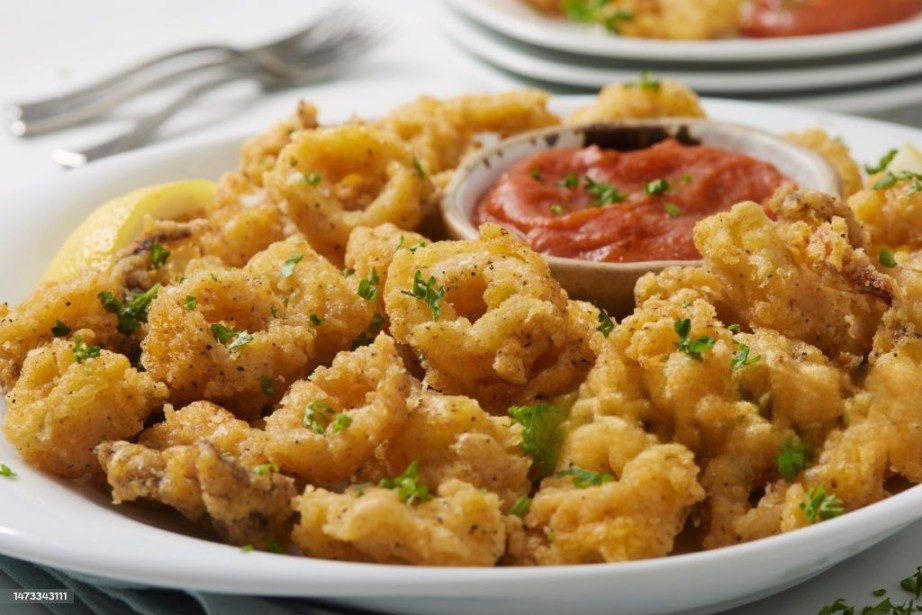 FRIED SQUID (150g).  ( well seasoned squid, dipped in butter) And deep fried , served on a bed of Coslaw and hot mayo sauce